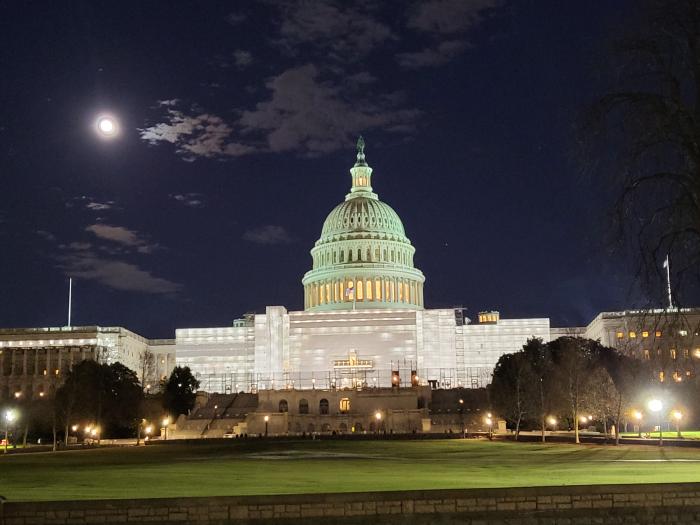 The full moon rises over the Capitol building on the evening of January 5, 2023.
