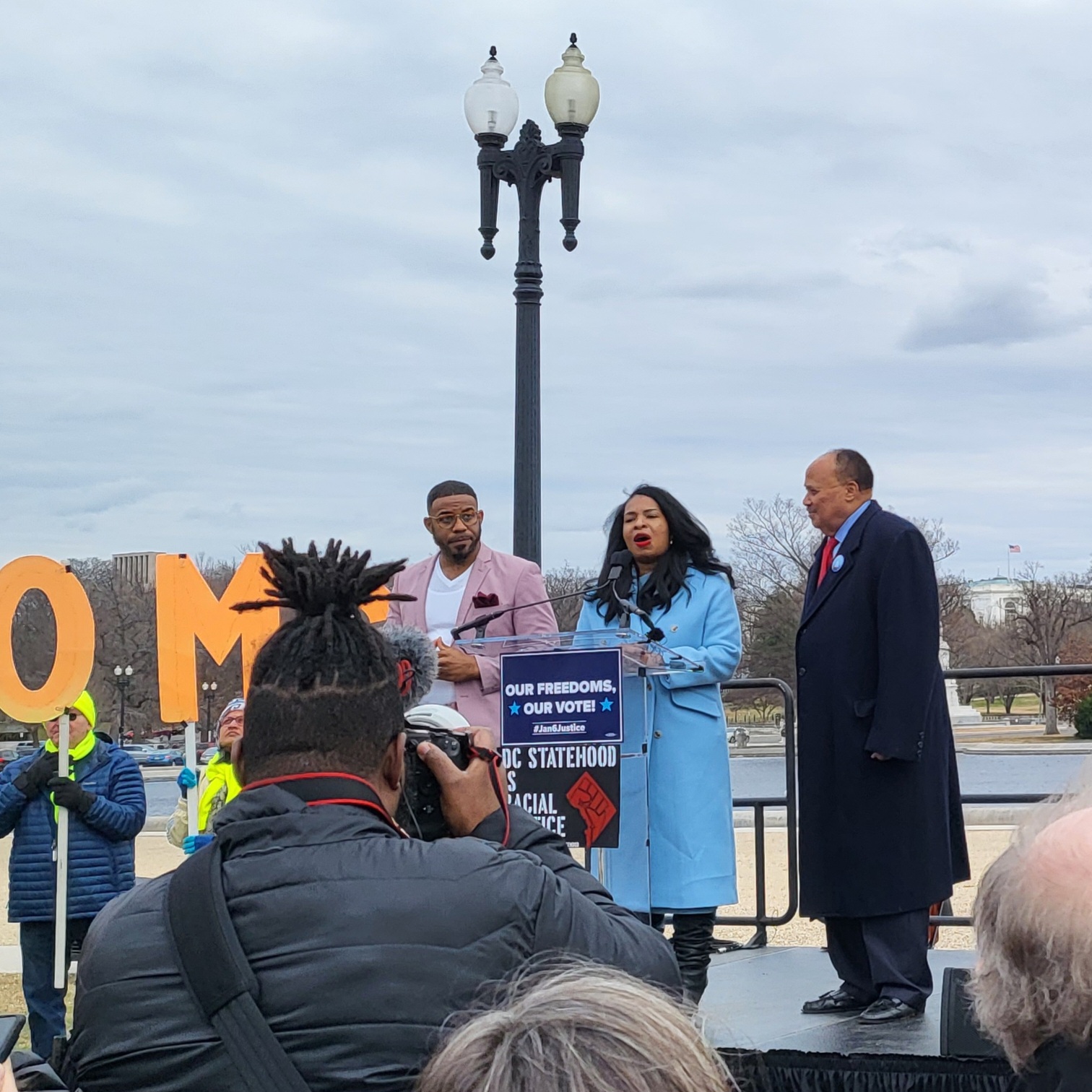 Arndrea Waters King and Martin Luther King III stand together on a stage beside an ASL interpreter. Mrs. King is speaking.